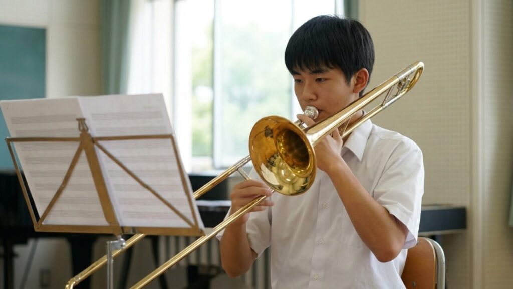 楽譜を見ながら音階練習をする日本人高校生男子