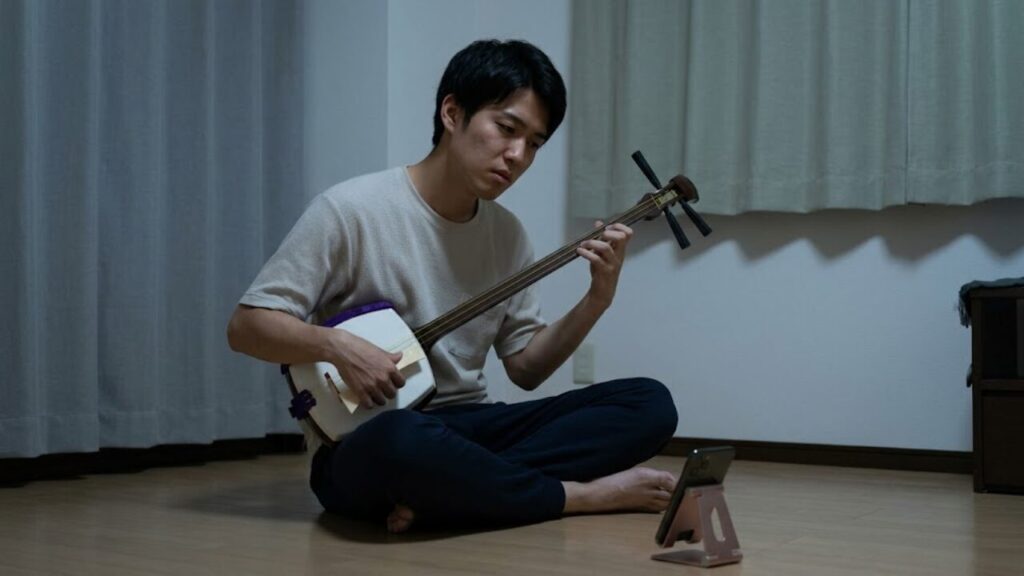独学で三味線を練習する日本人男性